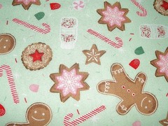 Flannel print scattered with iced Christmas cookies candy canes and gingerbread