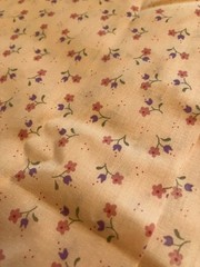 pink calico print fabric. 44 inches wide. 60 inches long except for a 10×14 in