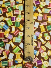 THREAD SPOOLS AND NEEDLES ON BROWN COTTON FQ