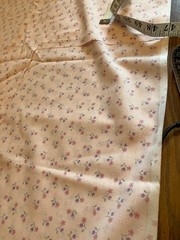 pink calico print fabric. 44 inches wide. 60 inches long except for a 10×14 in