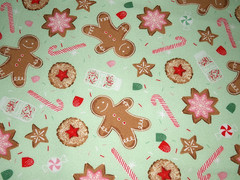 Flannel print scattered with iced Christmas cookies candy canes and gingerbread