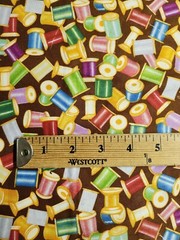 THREAD SPOOLS AND NEEDLES ON BROWN COTTON FQ