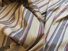 Woven satin and grosgrain stripe upholstery material in black, wine, gold multi