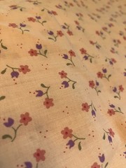 pink calico print fabric. 44 inches wide. 60 inches long except for a 10×14 in